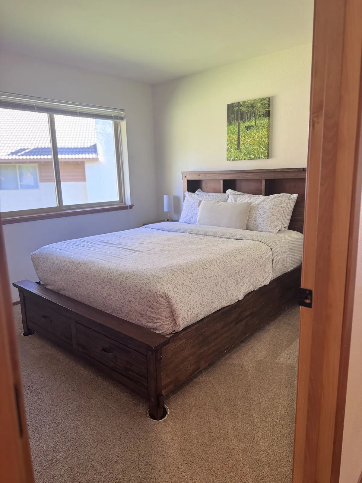 Made bed with white bedding, pillows and a dark headboard