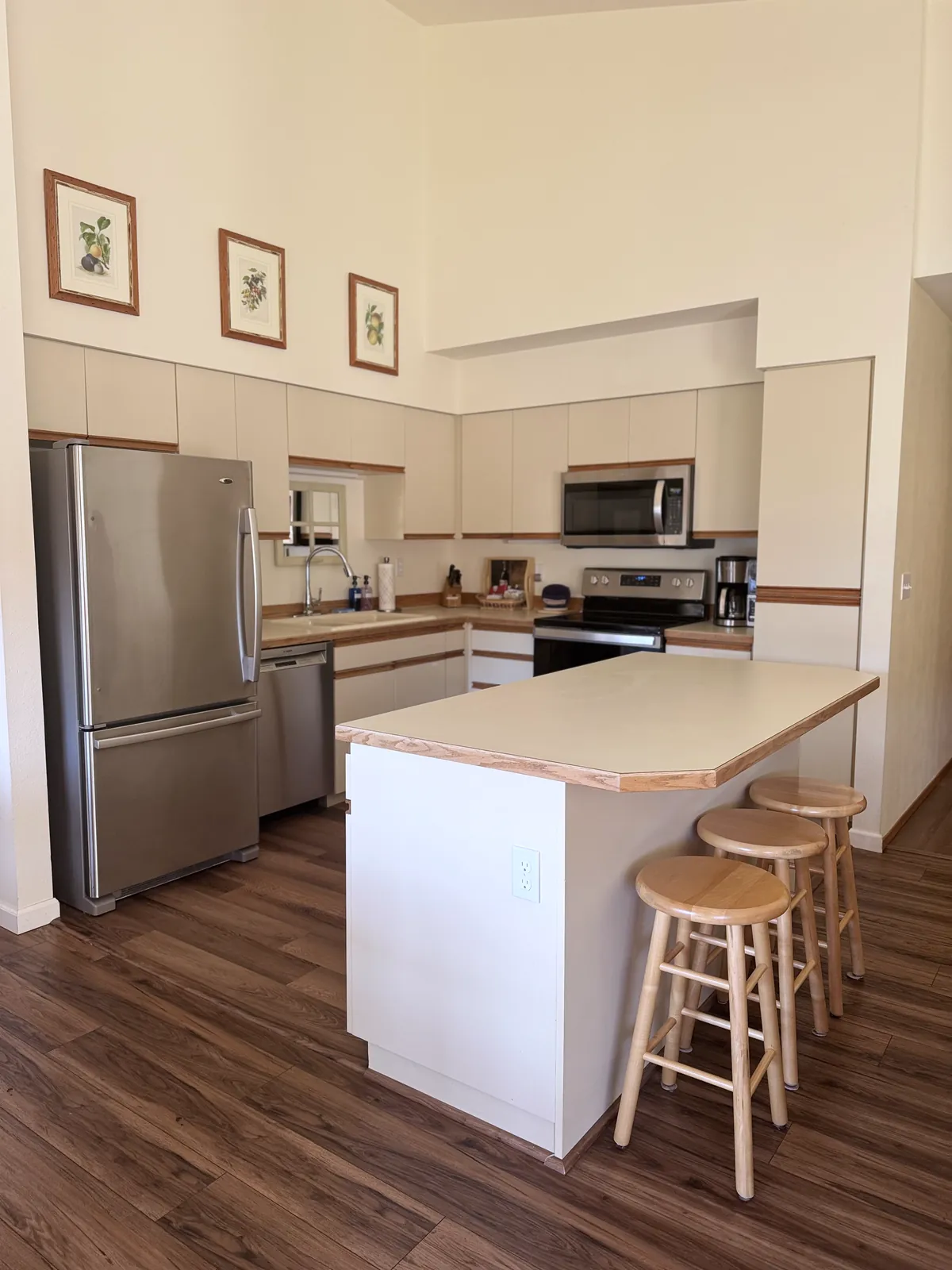 Bright kitchen with stainless appliances, an island and wooden stools