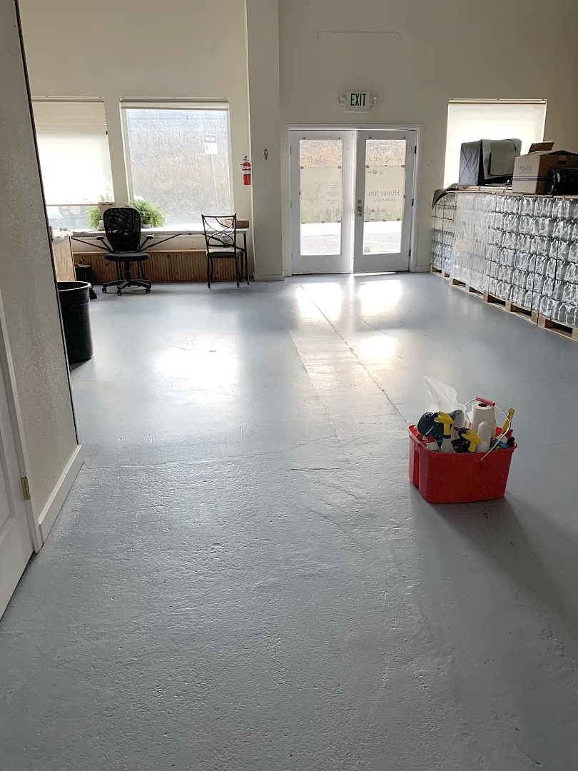Open workspace with a grey floor, glass doors and a red supply caddy